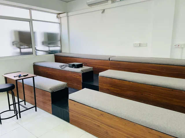 ILT classroom with tiered upholstered seating and a projector